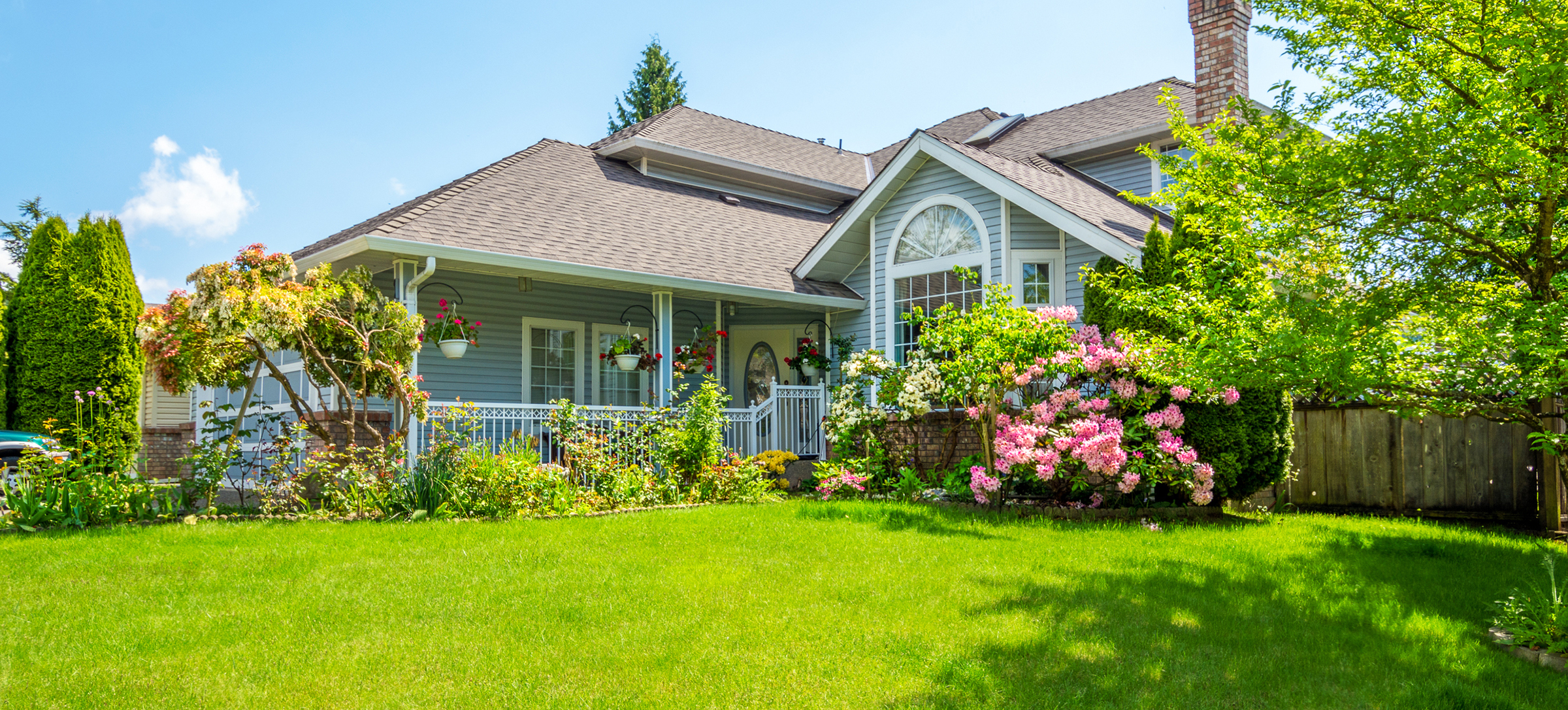 Entrance,Of,A,Luxury,House,With,A,Patio,And,Beautiful Entrance of a luxury house with a patio and beautiful landscaping on a bright, sunny day. Home exterior.